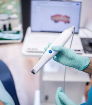 Close up of dentist holding a modern 3D dental scanner.
